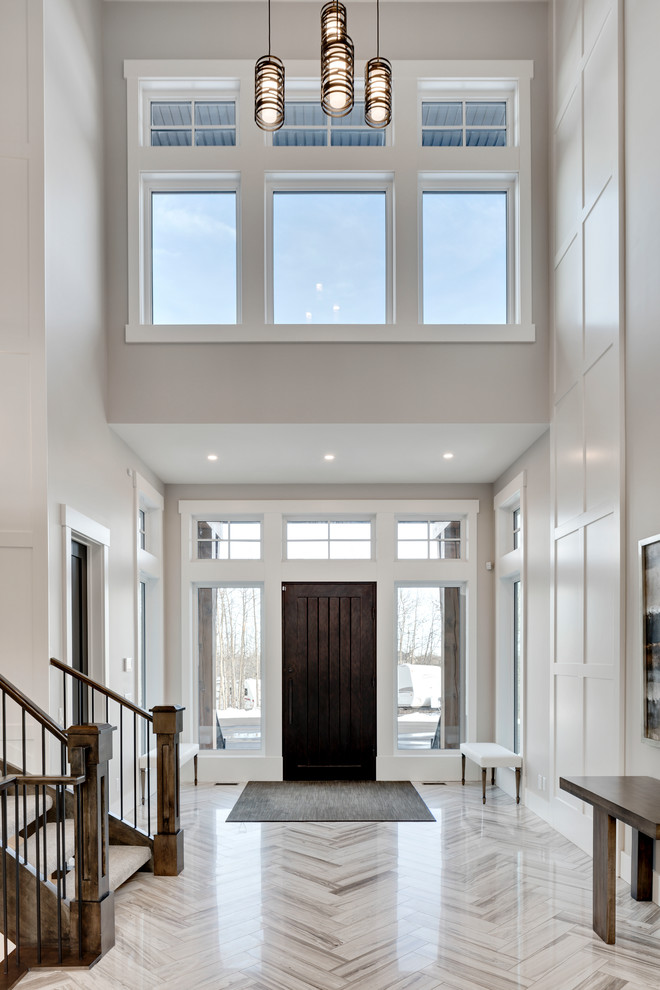 Huge transitional marble floor and white floor foyer photo in Calgary with gray walls and a dark wood front door