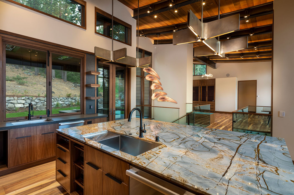 Photo of a large contemporary l-shaped open plan kitchen in Other with an undermount sink, flat-panel cabinets, medium wood cabinets, quartzite benchtops, blue splashback, stone slab splashback, stainless steel appliances, medium hardwood floors, with island, brown floor, blue benchtop and exposed beam.