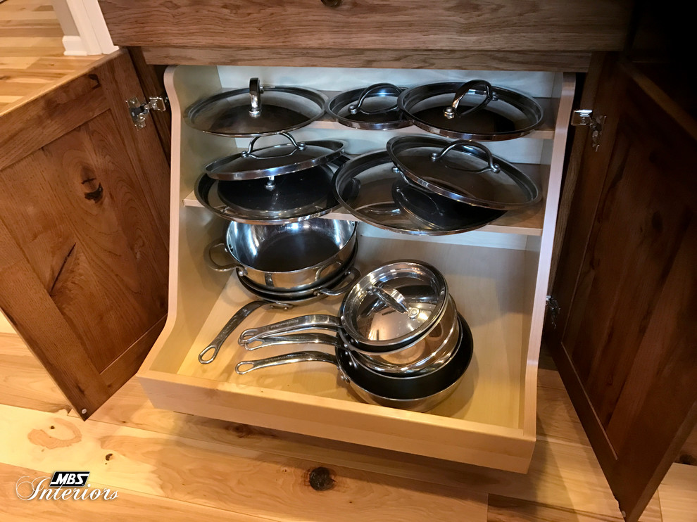 Example of a large mountain style l-shaped light wood floor and beige floor eat-in kitchen design with an undermount sink, raised-panel cabinets, medium tone wood cabinets, granite countertops, gray backsplash, ceramic backsplash, stainless steel appliances and an island