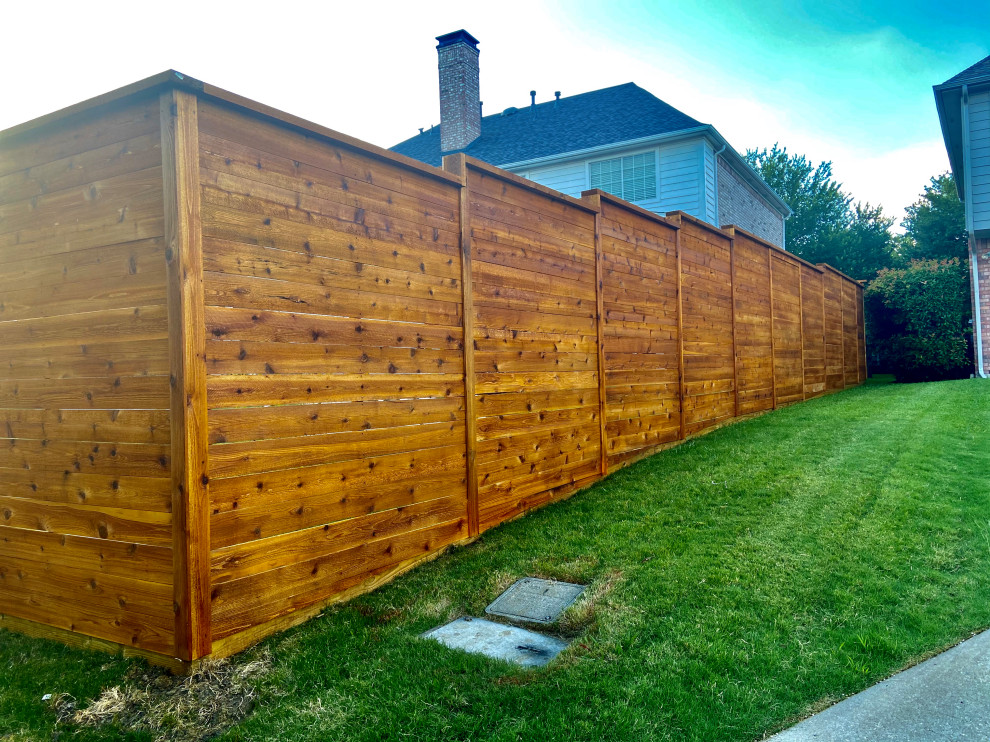 Idée de décoration pour un grand jardin arrière avec une clôture en bois.