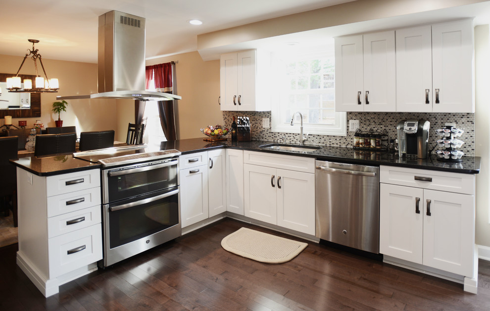 Example of a large transitional u-shaped vinyl floor eat-in kitchen design in Baltimore with a single-bowl sink, shaker cabinets, white cabinets, granite countertops, black backsplash, mosaic tile backsplash, stainless steel appliances and a peninsula
