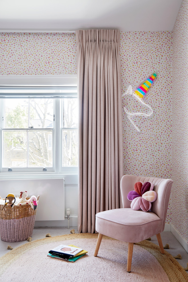 Photo of a small modern kids' bedroom for kids 4-10 years old and girls in London with pink walls, carpet and wallpaper.