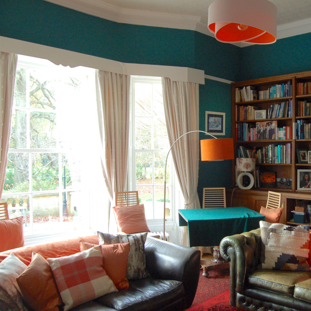 Modelo de salón blanco de estilo de casa de campo grande con paredes azules, suelo de madera en tonos medios, estufa de leña, marco de chimenea de piedra y televisor independiente