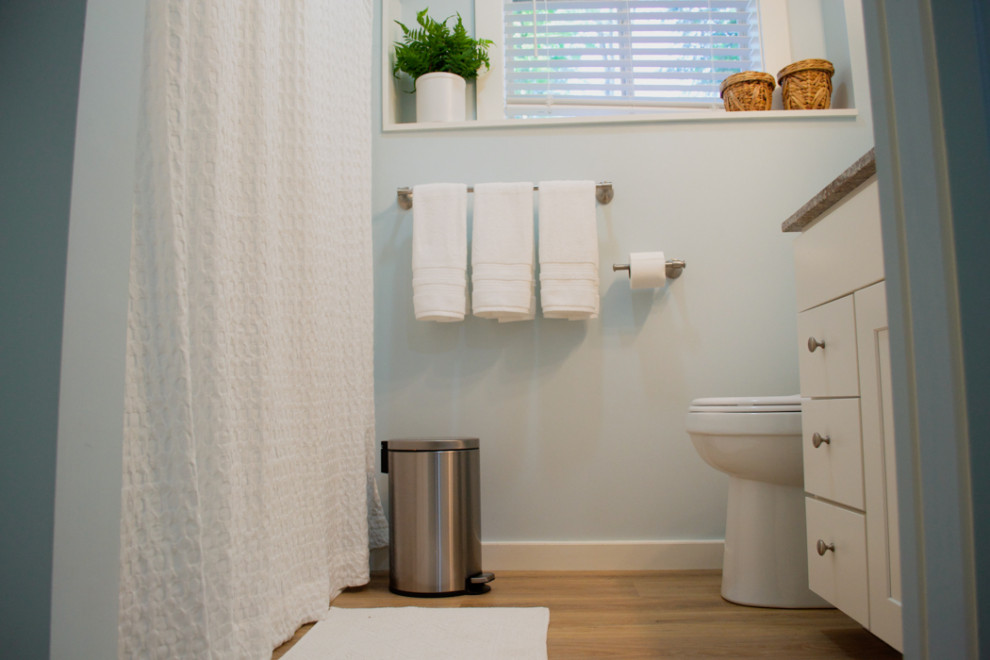 Idéer för ett litet klassiskt grå badrum, med luckor med infälld panel, vita skåp, ett badkar i en alkov, en dusch/badkar-kombination, blå väggar, bänkskiva i akrylsten och dusch med duschdraperi