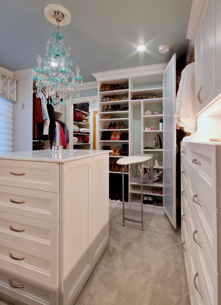 This is an example of a large traditional gender-neutral walk-in wardrobe in Other with white cabinets, carpet, beige floor and recessed-panel cabinets.