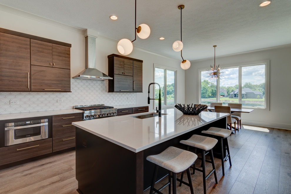 Eat-in kitchen - mid-sized 1960s l-shaped light wood floor and brown floor eat-in kitchen idea in Indianapolis with a drop-in sink, flat-panel cabinets, dark wood cabinets, granite countertops, white backsplash, ceramic backsplash, stainless steel appliances, an island and white countertops