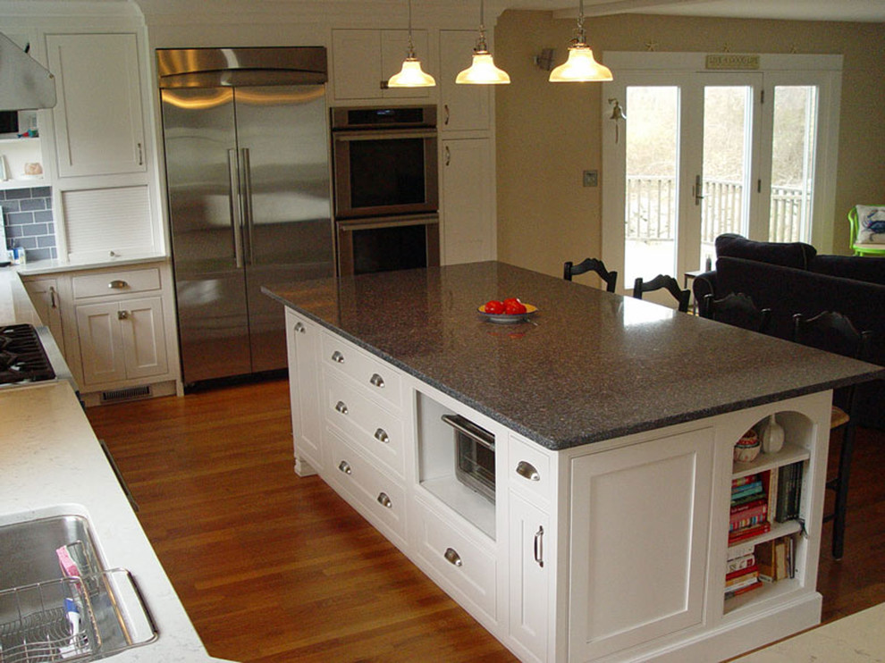 Design ideas for a large traditional u-shaped eat-in kitchen in Providence with a double-bowl sink, recessed-panel cabinets, white cabinets, grey splashback, ceramic splashback, stainless steel appliances, light hardwood floors, with island and quartz benchtops.
