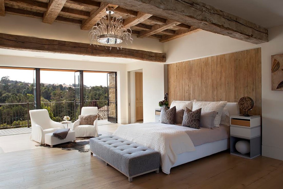 This is an example of a mediterranean master bedroom in San Francisco with white walls and medium hardwood floors.