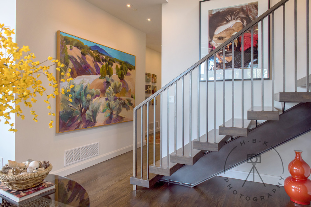 Example of a large medium tone wood floor and brown floor foyer design with white walls