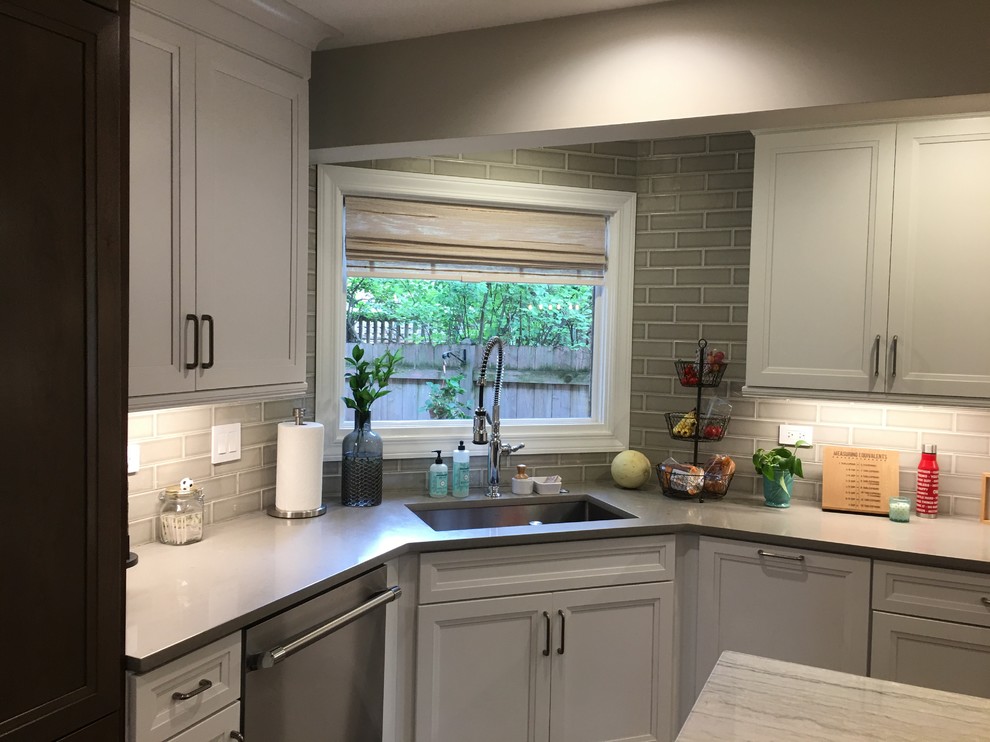 Example of a large transitional u-shaped dark wood floor and brown floor open concept kitchen design in Chicago with an undermount sink, flat-panel cabinets, white cabinets, quartz countertops, gray backsplash, ceramic backsplash, stainless steel appliances, an island and gray countertops