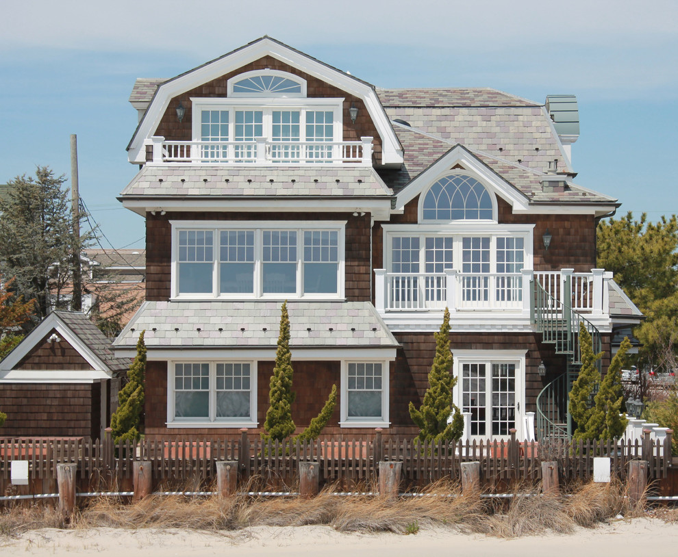 Photo of a beach style three-storey brown exterior in Philadelphia with wood siding and a gambrel roof.