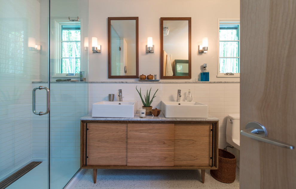 This is an example of a mid-sized transitional master bathroom in DC Metro with a vessel sink, furniture-like cabinets, medium wood cabinets, marble benchtops, an open shower, white tile, ceramic tile and white walls.