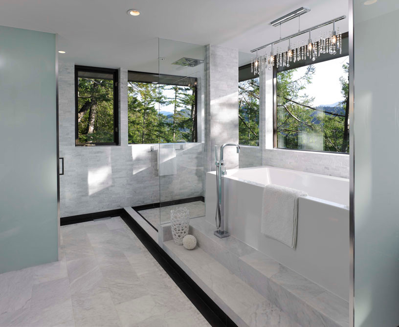 Large modern bathroom in Vancouver with a freestanding tub, a corner shower, a wall-mount toilet and gray tile.