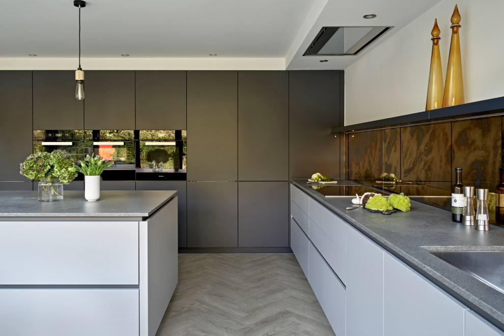 This is an example of a large contemporary l-shaped eat-in kitchen in Surrey with an undermount sink, flat-panel cabinets, grey cabinets, quartzite benchtops, metallic splashback, mirror splashback, vinyl floors, with island and grey benchtop.