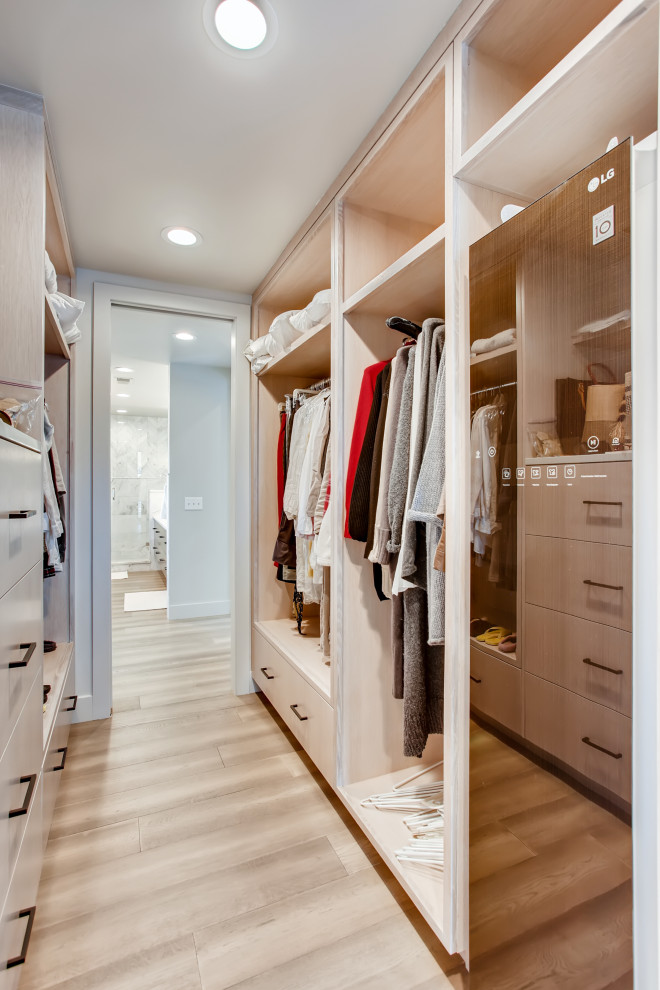Contemporary walk-in wardrobe in Denver with open cabinets, light wood cabinets and beige floor.