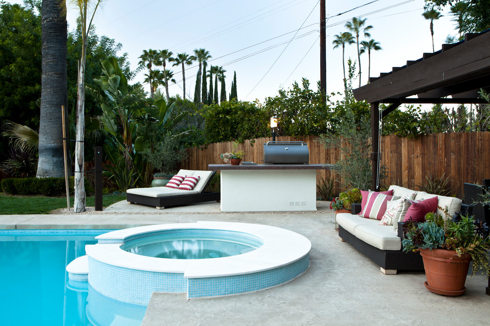 Photo of a mediterranean round pool in Los Angeles with a hot tub and concrete slab.