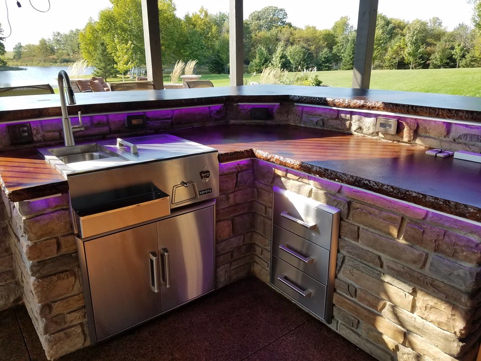 Mid-sized country backyard patio in Minneapolis with an outdoor kitchen, stamped concrete and a pergola.