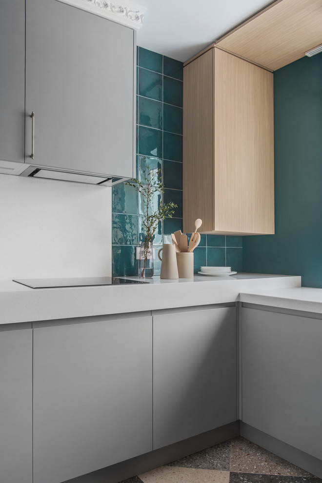 Eclectic u-shaped separate kitchen in Moscow with flat-panel cabinets, grey cabinets, solid surface benchtops, green splashback, ceramic splashback, no island, multi-coloured floor and white benchtop.