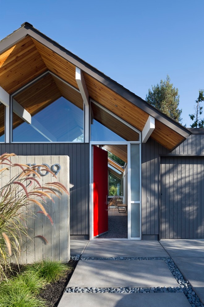 Photo of a midcentury entryway in San Francisco with a single front door and a red front door.