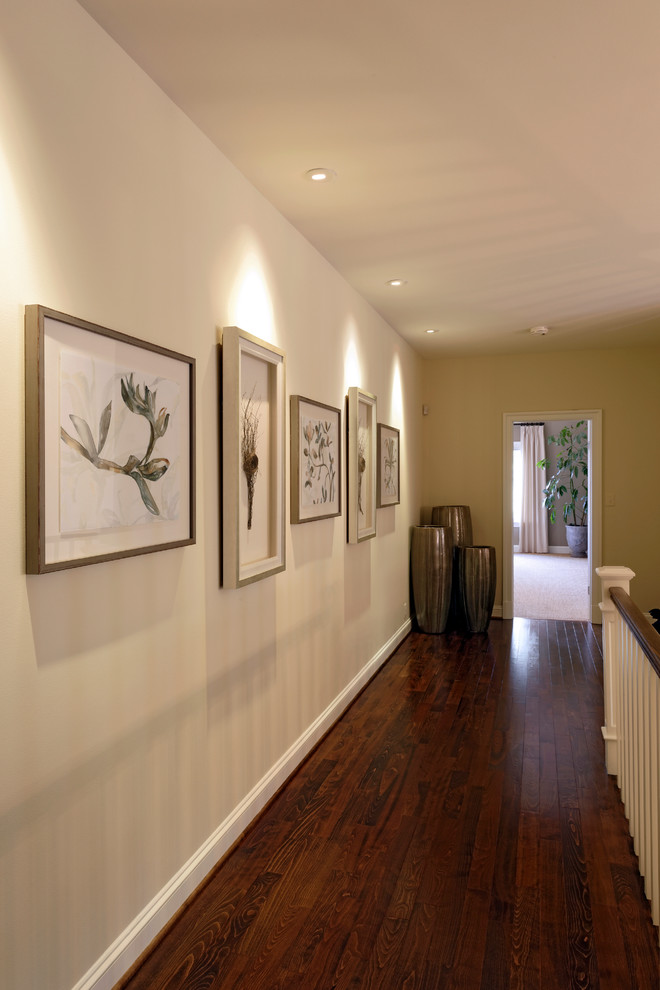 This is an example of a large traditional hallway in DC Metro with beige walls and dark hardwood floors.