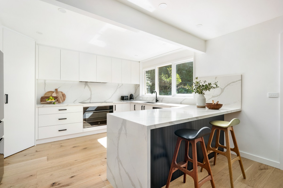 Photo of a modern kitchen in Sydney with quartz benchtops and engineered quartz splashback.