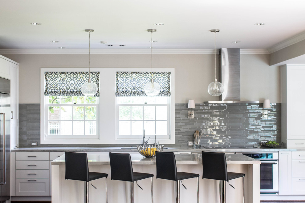 Open concept kitchen - large transitional l-shaped dark wood floor open concept kitchen idea in Houston with a double-bowl sink, shaker cabinets, white cabinets, quartzite countertops, gray backsplash, glass tile backsplash, stainless steel appliances and an island