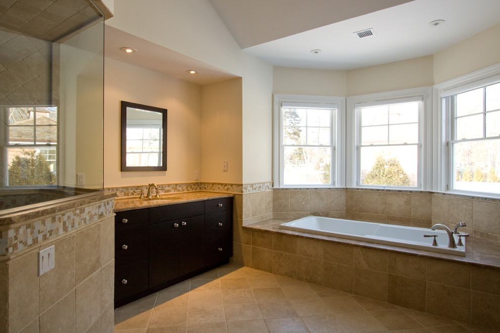 Large transitional master beige tile and mosaic tile porcelain tile drop-in bathtub photo with black cabinets, beige walls, an undermount sink and granite countertops
