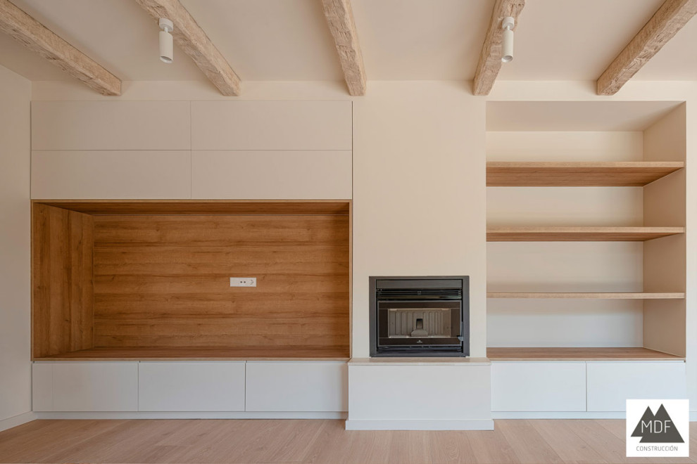 Imagen de salón blanco y madera mediterráneo grande con paredes blancas, suelo de madera clara, chimenea lineal, marco de chimenea de metal, suelo marrón y vigas vistas