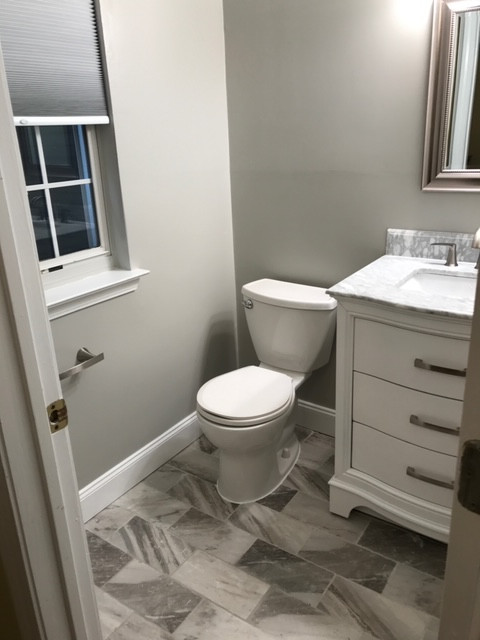 Small transitional marble floor and multicolored floor powder room photo with furniture-like cabinets, white cabinets, a two-piece toilet, gray walls, an undermount sink, marble countertops and gray countertops
