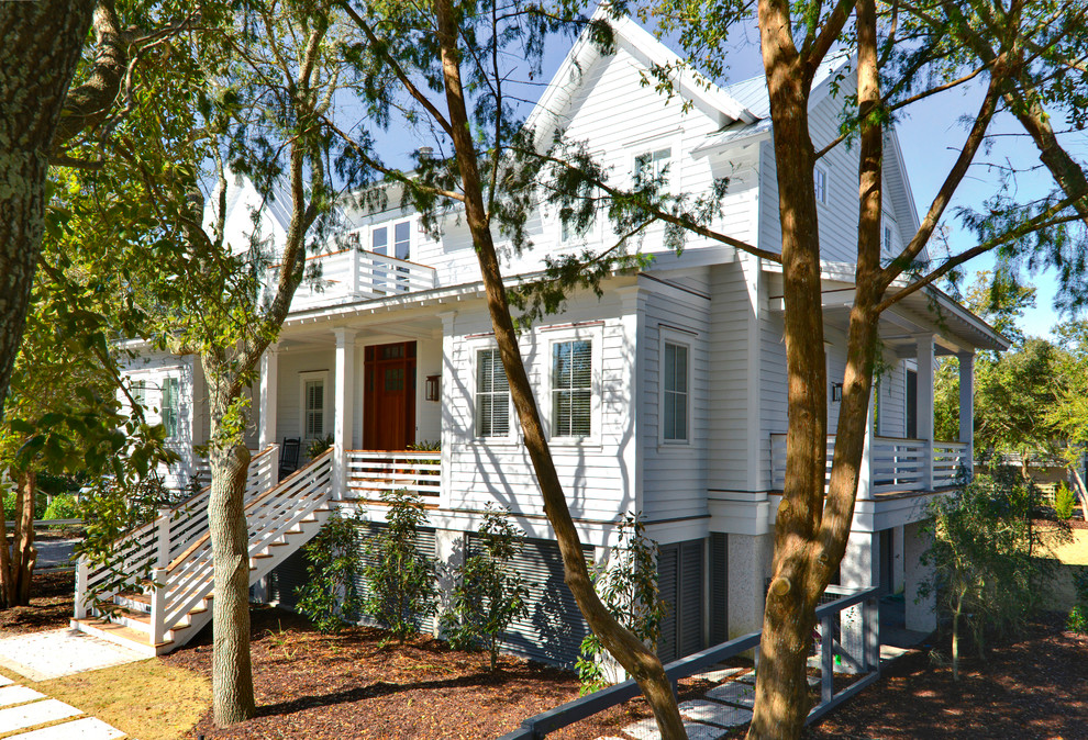 Photo of a mid-sized beach style two-storey white exterior in Charleston with concrete fiberboard siding and a gable roof.