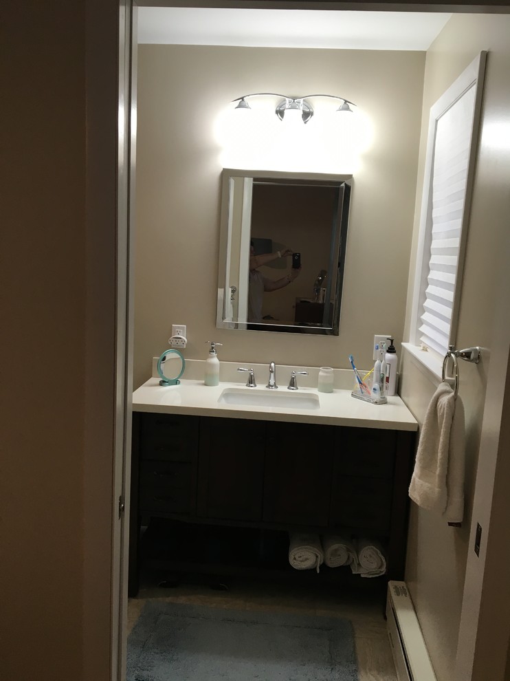 Alcove shower - small transitional 3/4 alcove shower idea in Baltimore with black cabinets, a one-piece toilet, brown walls, an undermount sink, solid surface countertops, a hinged shower door and white countertops
