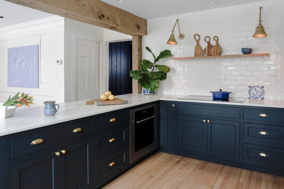 Inspiration for a small classic u-shaped kitchen/diner in New York with a belfast sink, shaker cabinets, blue cabinets, marble worktops, white splashback, ceramic splashback, integrated appliances, marble flooring, no island, beige floors, white worktops and exposed beams.