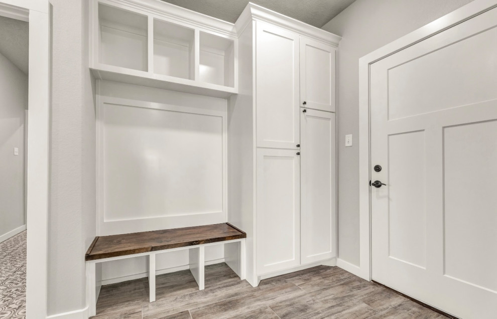 Ejemplo de lavadero multiusos de estilo de casa de campo de tamaño medio con armarios estilo shaker, puertas de armario blancas, paredes grises y suelo beige