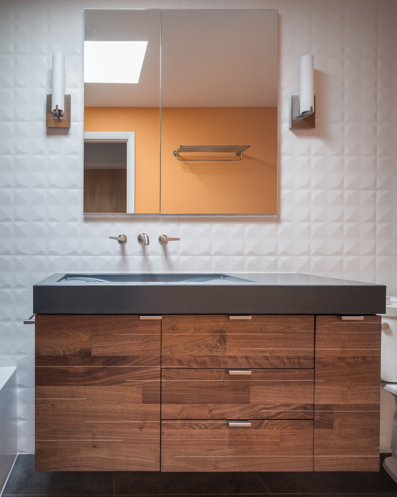 На фото: главная ванная комната среднего размера в стиле ретро с плоскими фасадами, фасадами цвета дерева среднего тона, ванной в нише, душем в нише, раздельным унитазом, белой плиткой, керамогранитной плиткой, оранжевыми стенами, полом из керамогранита, монолитной раковиной, столешницей из бетона, серым полом, шторкой для ванной, синей столешницей, нишей, тумбой под одну раковину и подвесной тумбой с