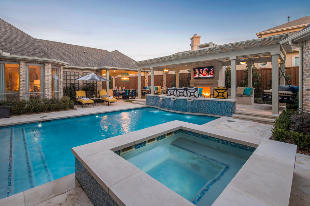 Mid-sized transitional backyard rectangular pool in Dallas with a water feature and natural stone pavers.