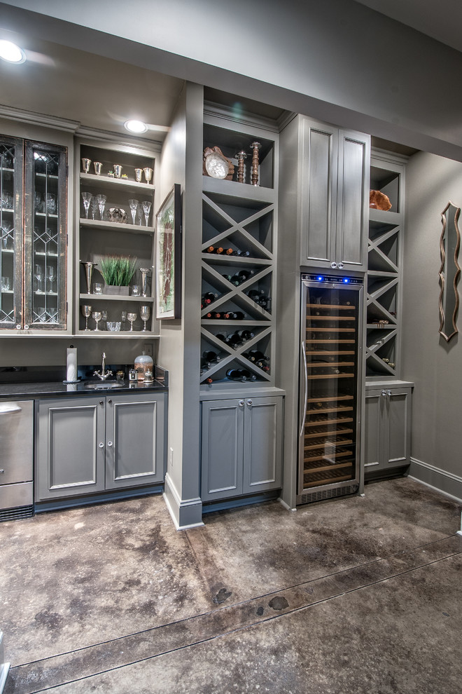 Mid-sized transitional wine cellar in Other with concrete floors and storage racks.
