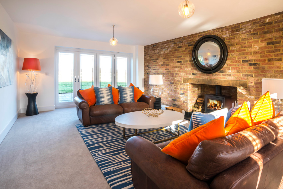 Photo of a transitional formal enclosed living room in Kent with multi-coloured walls, carpet, a wood stove, a brick fireplace surround and grey floor.