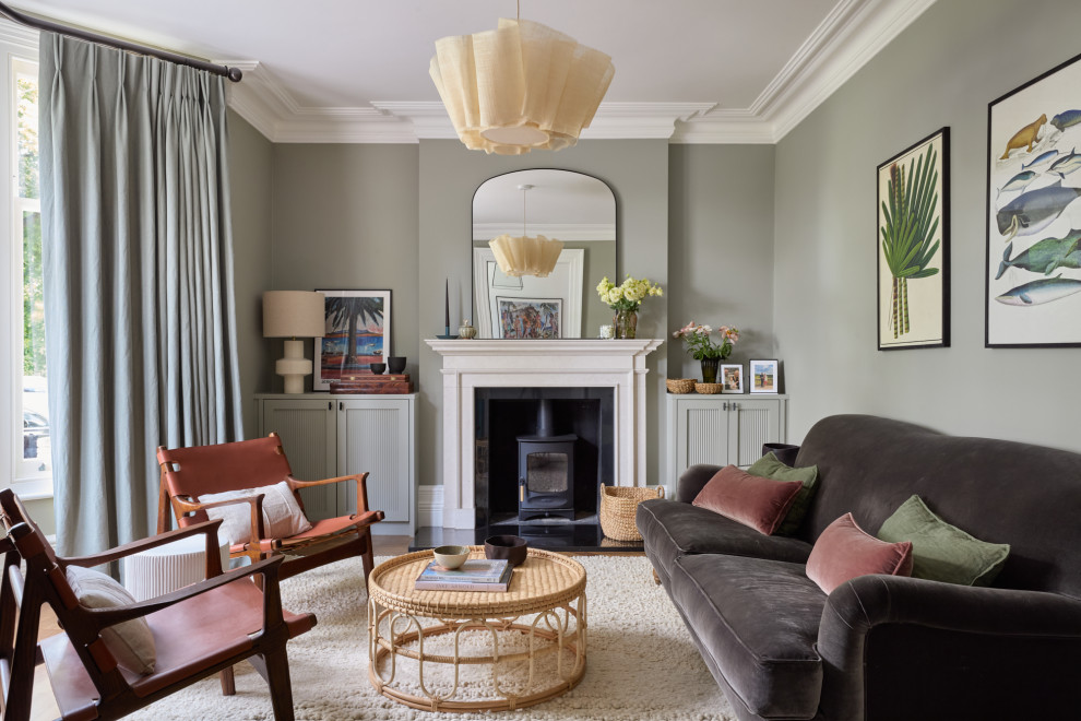 Inspiration for a large classic enclosed living room in London with green walls, dark hardwood flooring, a wood burning stove, a stone fireplace surround and feature lighting.