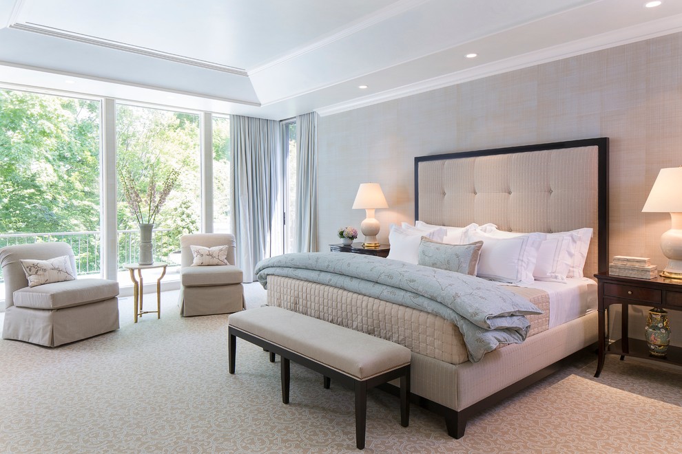 This is an example of a large transitional master bedroom in New York with grey walls, carpet and no fireplace.