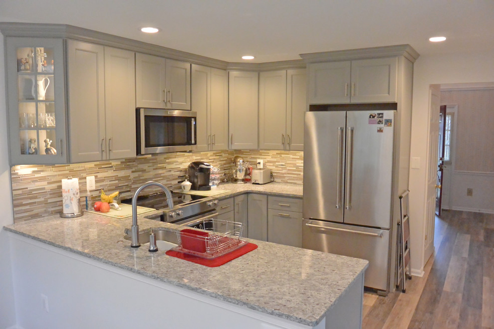Eat-in kitchen - small transitional u-shaped vinyl floor and brown floor eat-in kitchen idea in DC Metro with an undermount sink, shaker cabinets, gray cabinets, granite countertops, gray backsplash, mosaic tile backsplash, stainless steel appliances, a peninsula and gray countertops