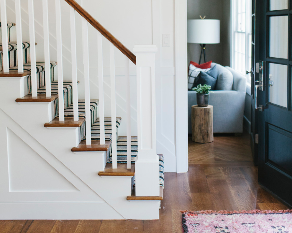 Photo of an eclectic entryway in Salt Lake City with white walls and dark hardwood floors.