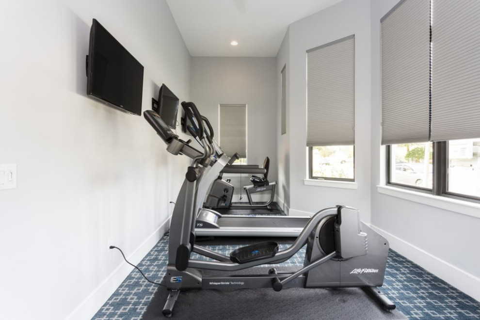 Inspiration for a small contemporary multipurpose gym in Orlando with beige walls, carpet and blue floor.