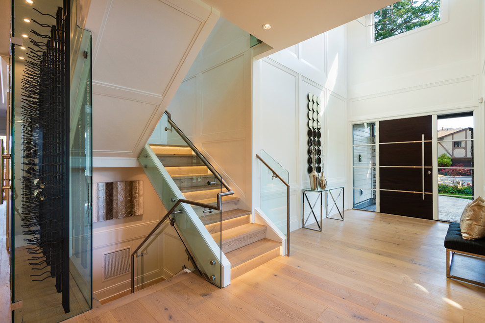 Example of a mid-sized transitional light wood floor and beige floor foyer design in Vancouver with white walls and a dark wood front door