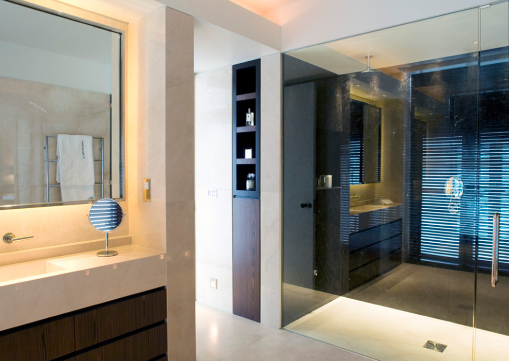 This is an example of a large contemporary master bathroom in London with flat-panel cabinets, brown cabinets, an open shower, beige tile, marble, beige walls, marble floors, an integrated sink, marble benchtops, beige floor, a hinged shower door, beige benchtops, a single vanity and a built-in vanity.