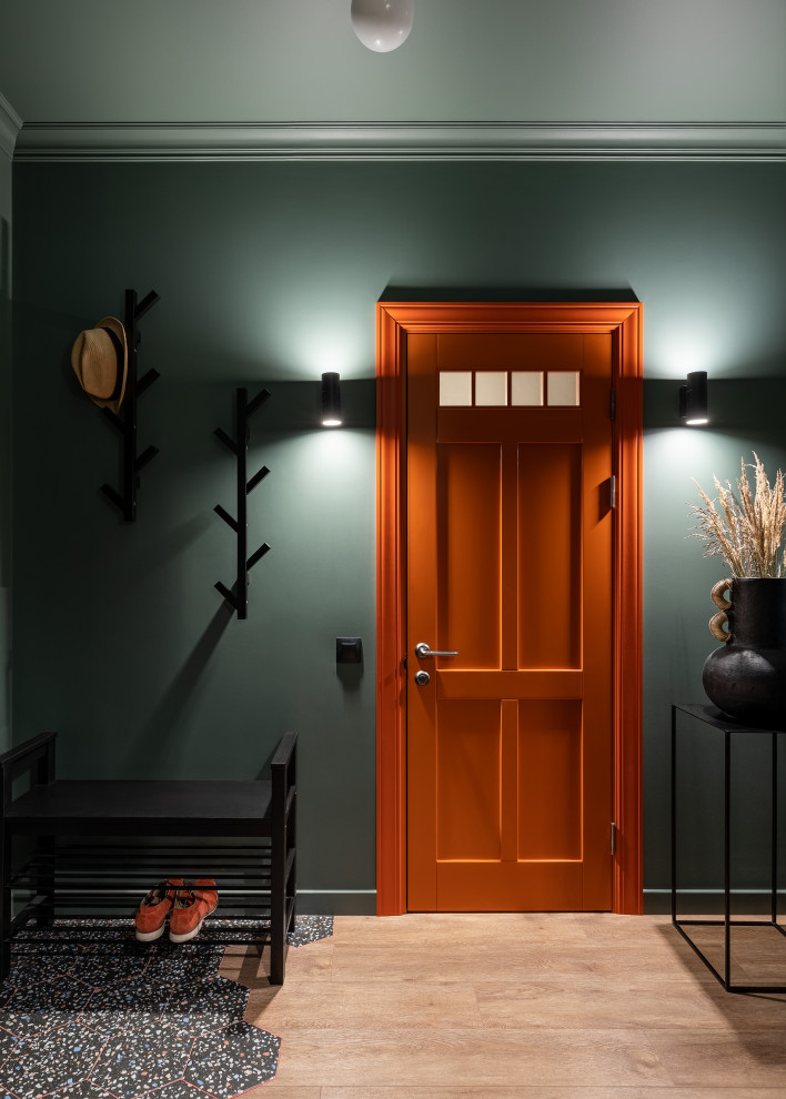 На фото: маленькая узкая прихожая: освещение в современном стиле с паркетным полом среднего тона, одностворчатой входной дверью, оранжевой входной дверью и коричневым полом для на участке и в саду