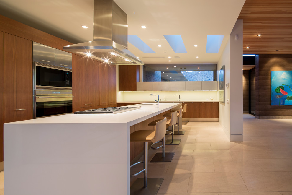 Photo of a contemporary l-shaped open plan kitchen in Phoenix with flat-panel cabinets, medium wood cabinets, stainless steel appliances and an undermount sink.