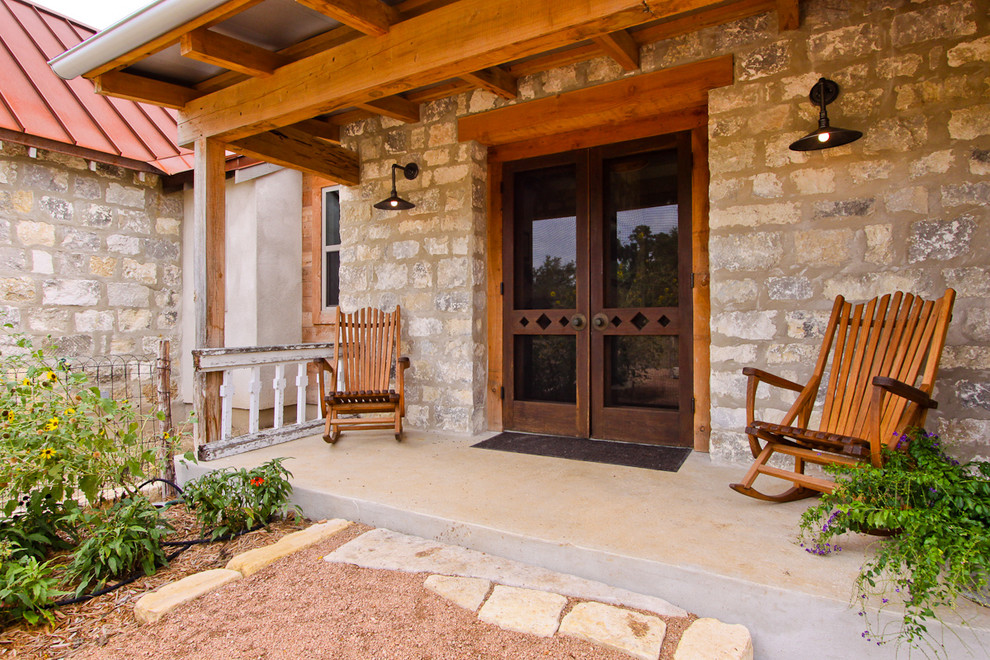 This is an example of a mid-sized country front yard verandah in Austin with concrete slab and a roof extension.