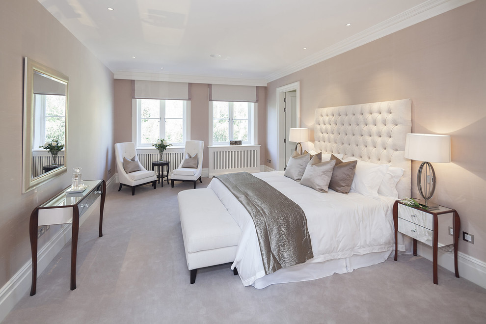 Inspiration for a mid-sized traditional master bedroom in London with beige walls and carpet.