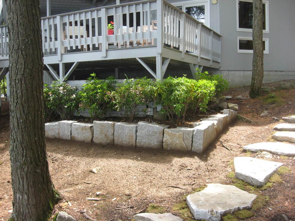 Photo of a mid-sized eclectic backyard shaded garden for summer in Portland Maine with a retaining wall and natural stone pavers.