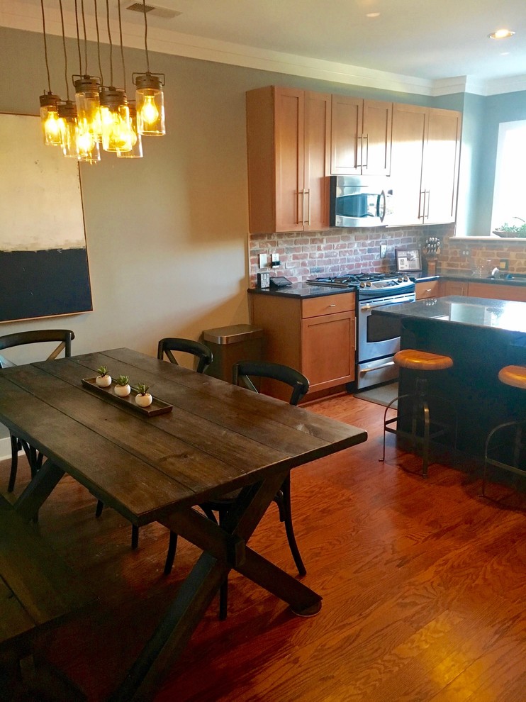 Esempio di una sala da pranzo aperta verso la cucina industriale di medie dimensioni con pareti verdi, pavimento in legno massello medio e pavimento marrone